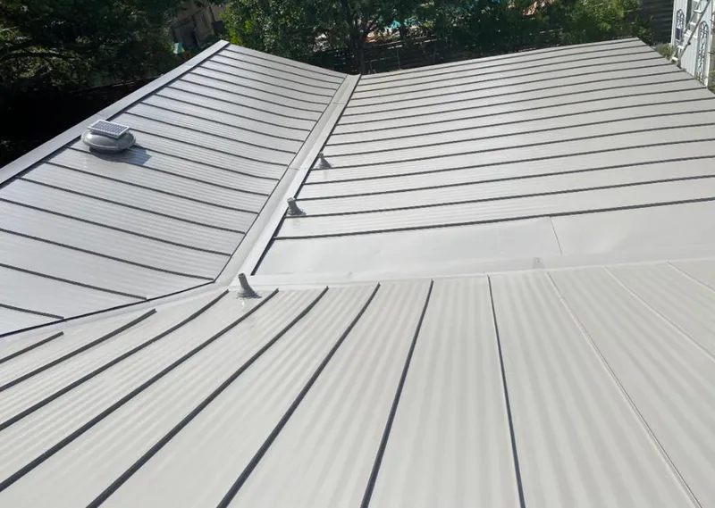 Solar attic fan installed on a metal roof for Roof Ventilation in Landen