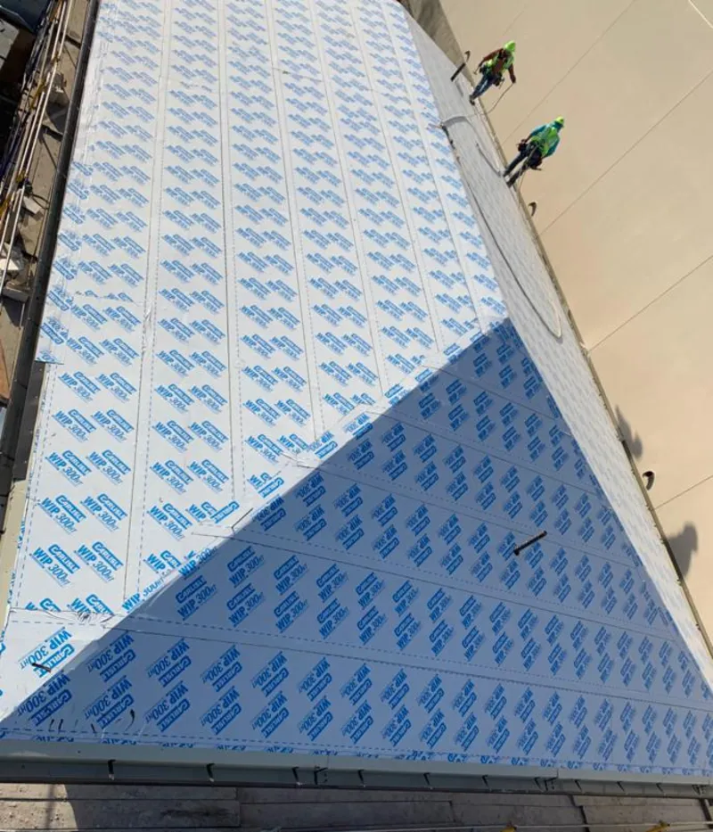 Professional roofers installing underlayment on a metal roof in Landen